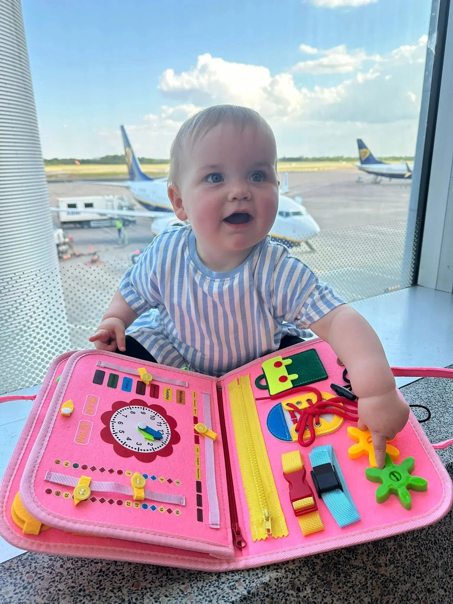 Child playing with busy book at an airport